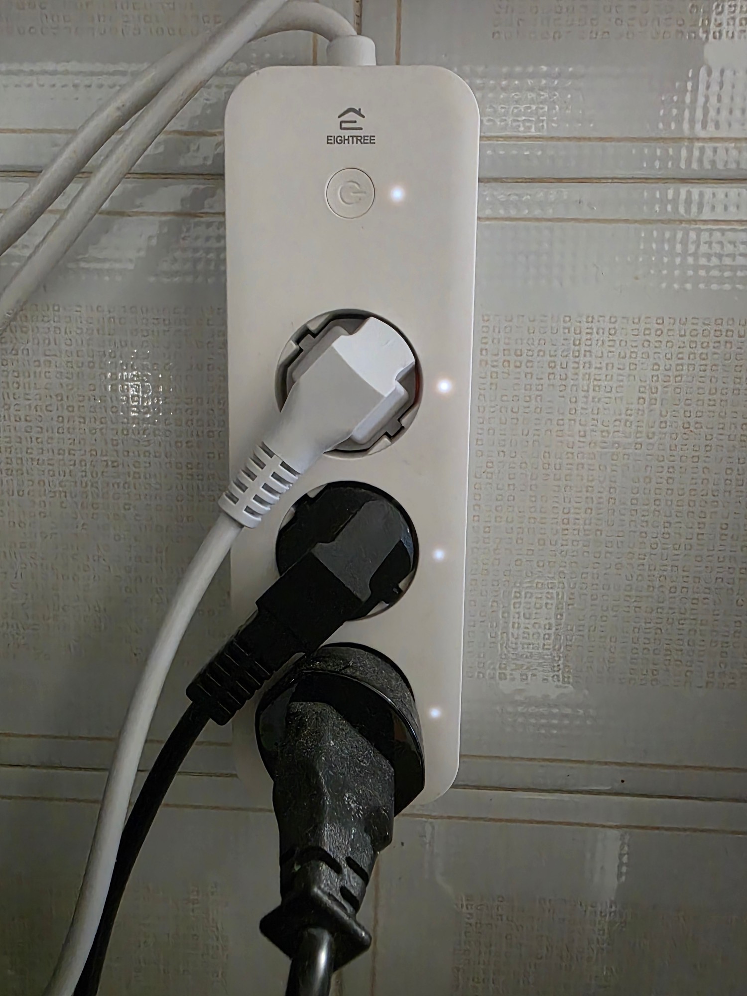 EIGHTREE Multipresa WiFi 3 Prese collegata a una presa a muro, con i LED di stato accesi vicino a ogni presa