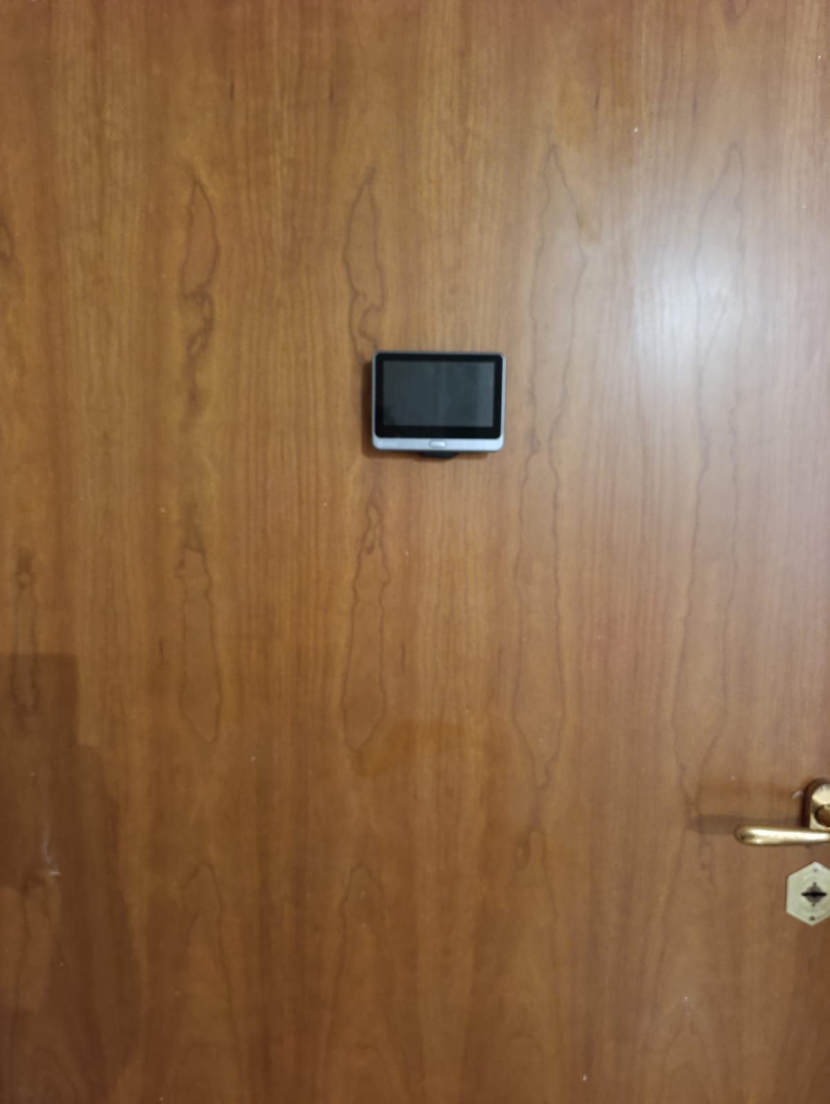 Monitor EZVIZ CP4 montato al centro di una porta in legno, all'altezza del vecchio spioncino