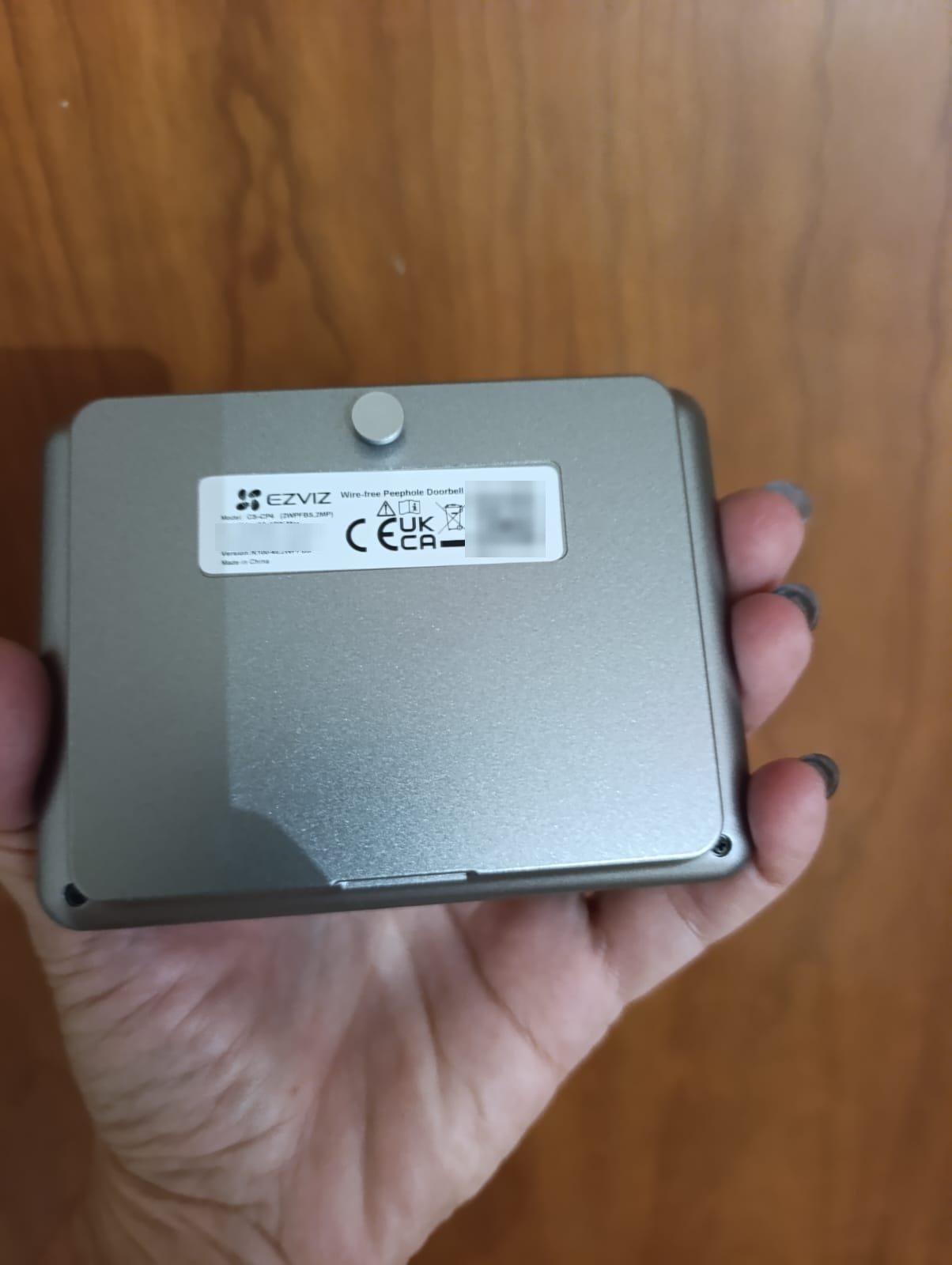 Retro argentato del monitor EZVIZ CP4 con l'etichetta del modello, numero di serie e QR oscurati