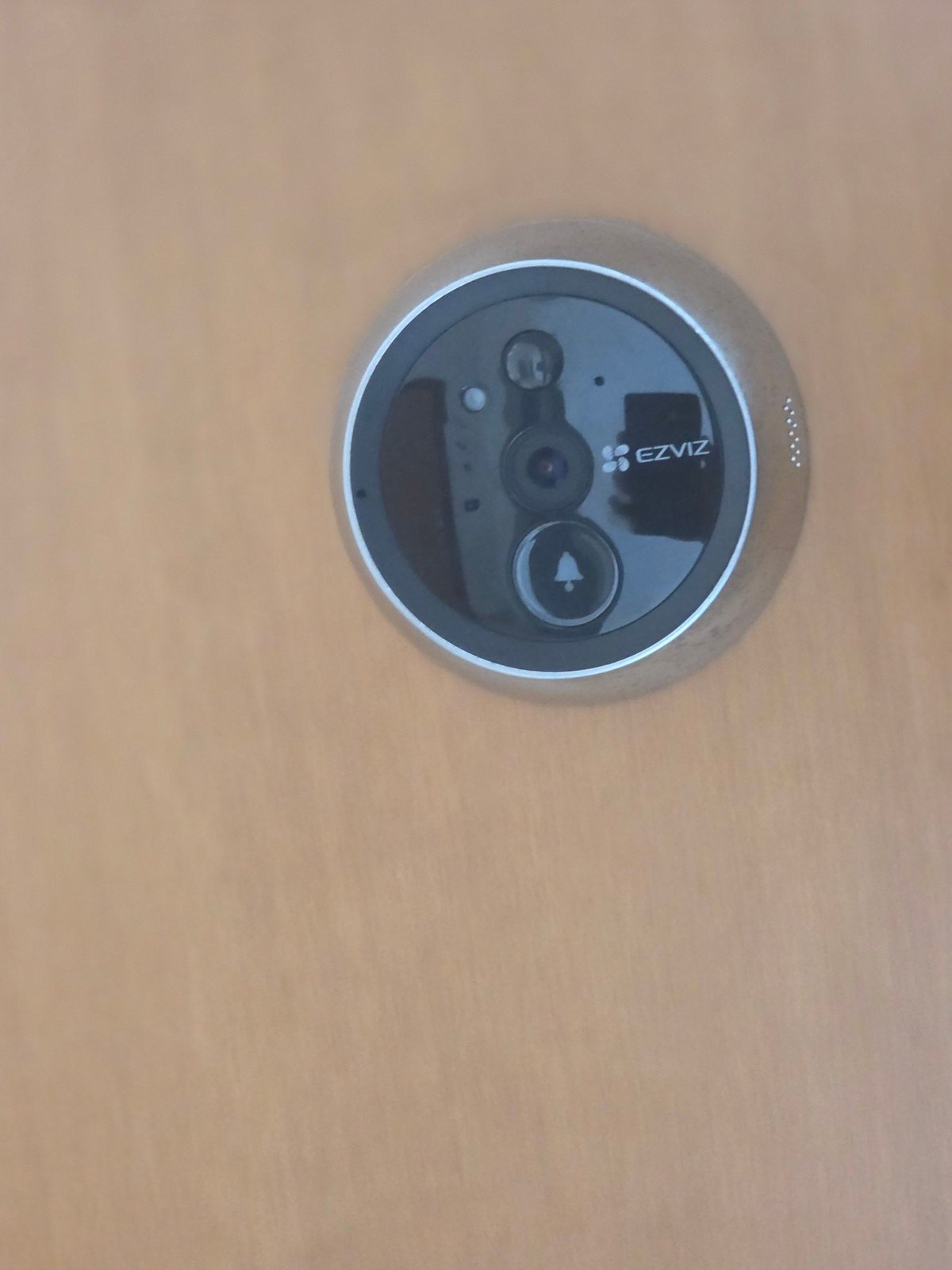 Telecamera esterna dell'EZVIZ DP1C sulla porta, con obiettivo, sensore e pulsante del campanello