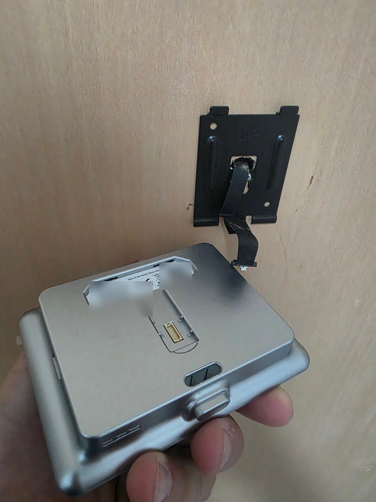Monitor EZVIZ DP1C sganciato dalla staffa, con il cavo piatto collegato e la presa sul retro