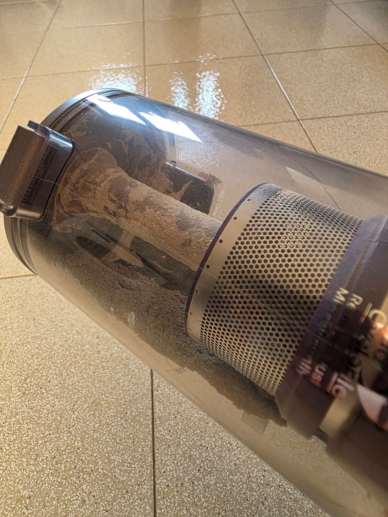 Contenitore trasparente del JIMMY BX8 Pro con polvere accumulata contro il filtro dopo l'uso