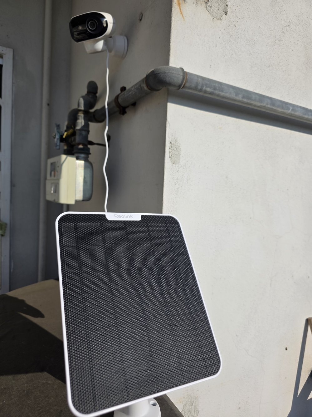 Reolink Argus 4 Pro montata sul muro del balcone con il Solar Panel 2 sulla ringhiera al sole