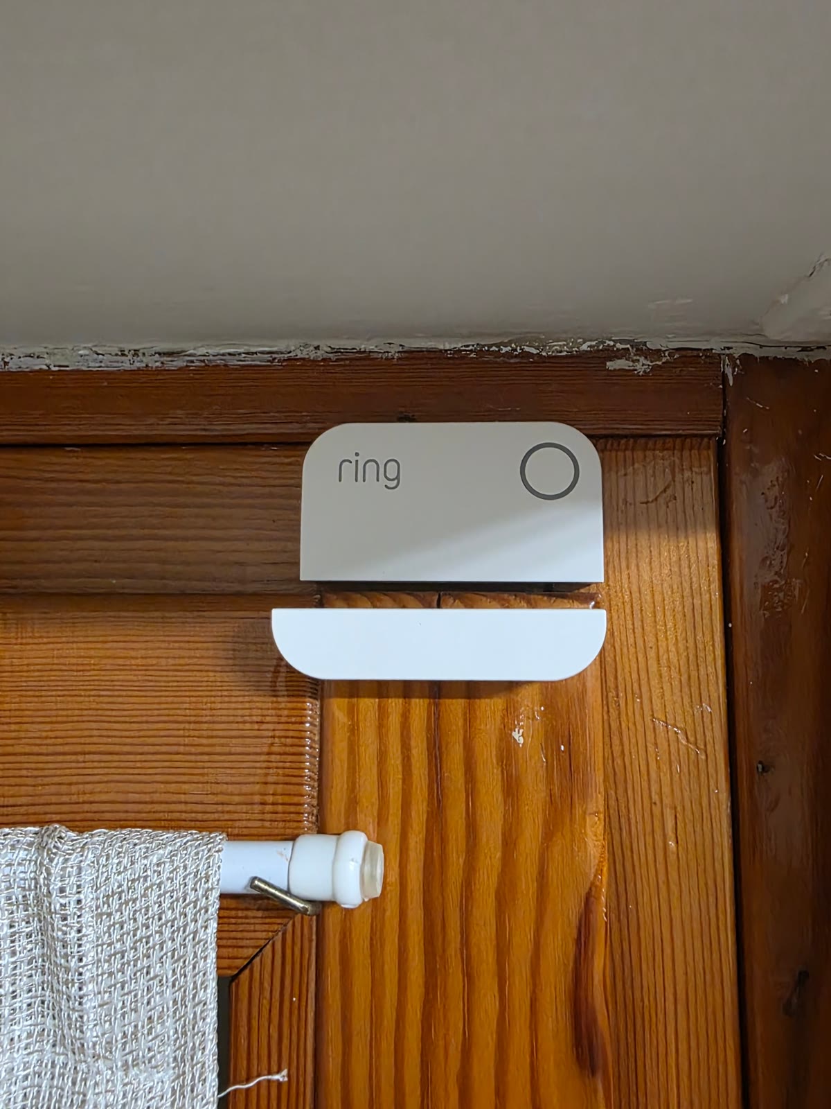 Sensore di contatto Ring Alarm sul telaio in legno di una finestra, con il magnete sull'anta