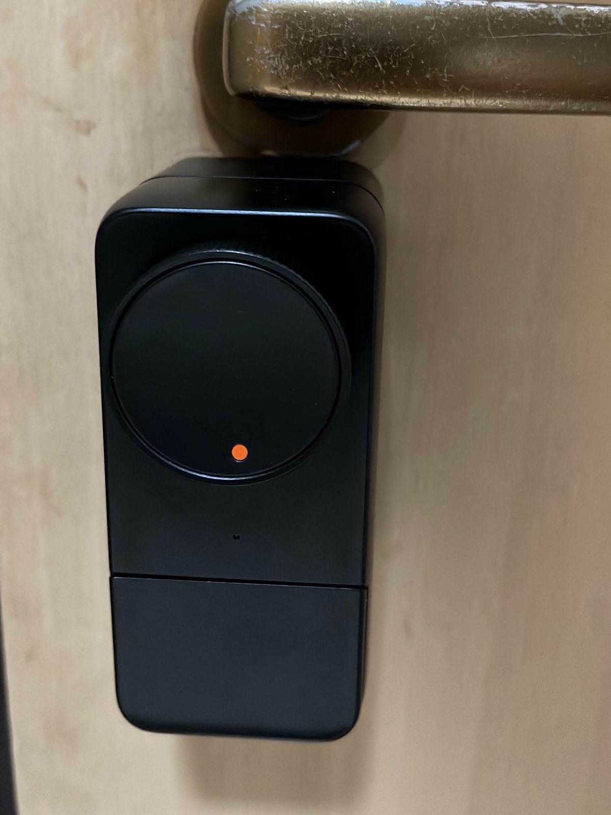 Primo piano della SwitchBot Lock Pro con il pomolo rotondo e il punto arancione