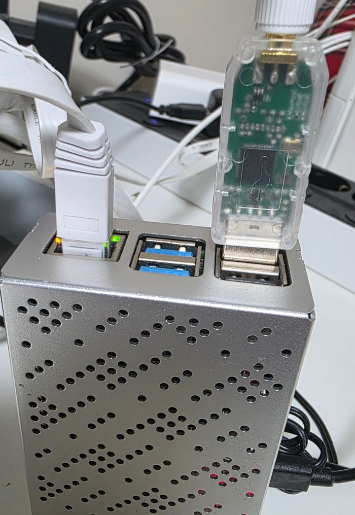 Raspberry Pi 4 in case di metallo con il cavo di rete e la SLZB-07p7 inserita nella porta USB nera, accanto alle porte USB 3 blu
